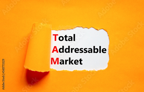 TAM total addressable market symbol. Concept words TAM total addressable market on white paper on a beautiful orange background. Business TAM total addressable market concept. Copy space. photo