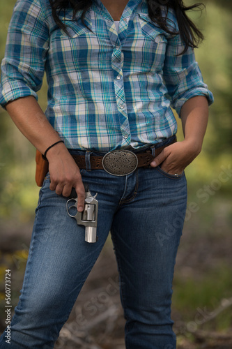 A western woman holds her revolver at ready.