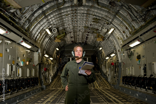 A U.S. Air Force loadmaster runs down her checklist in the cargo area during preflight. photo