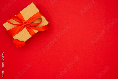 Gift box against red background. Holiday greeting card. Copy space. The concept of holidays and love