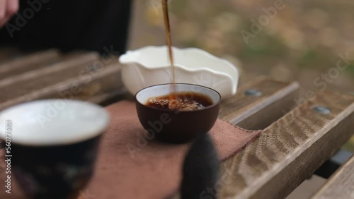 close-up dark pu-erh is poured into bowls for tea. Chinese tea ceremony