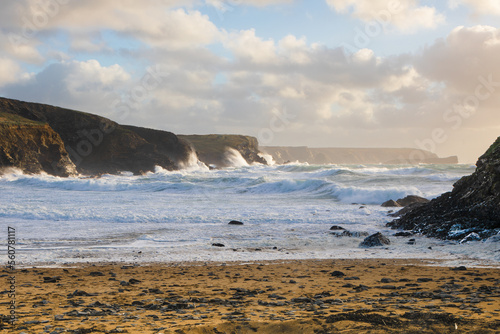 Seashore scene showing frothy white sea water rolling onto a Beach Dollar Cove, The Lizard, Cornwall