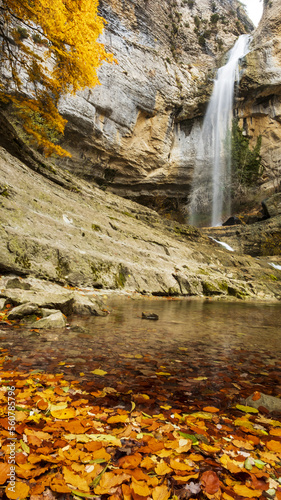 Fototapeta Naklejka Na Ścianę i Meble -  Waterfall next to a tree with autumn colors in Artazul, Ollo valley, Navarra, Spain