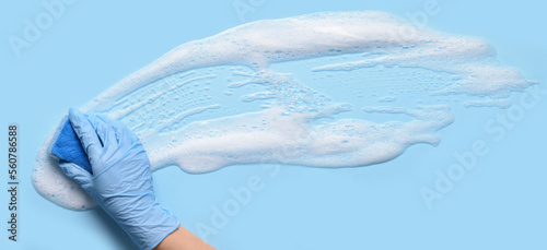 Konstfotografi Hand with sponge cleaning light blue surface