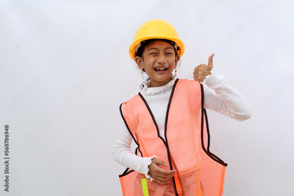 Cute Asian little girl in the construction helmet as an engineer showing thumbs up. Isolated on white with copyspace