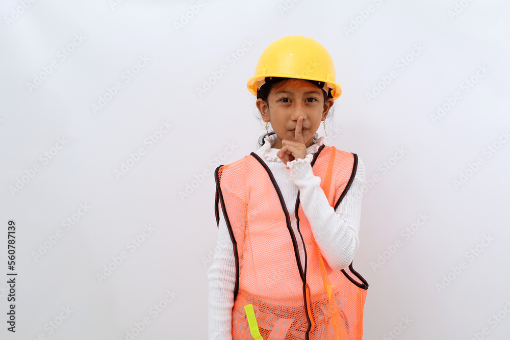 Adorable Asian little girl in the construction helmet as an engineer showing silent hand gesture. Isolated on white