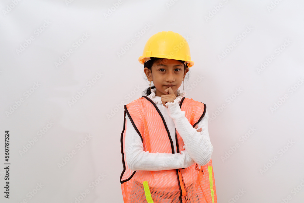 Thoughtful Asian little girl in the construction helmet as an engineer ...