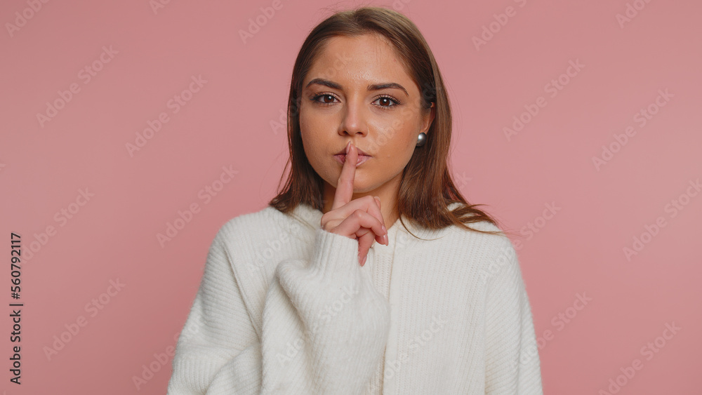 Shh be quiet please. Portrait of millennial adult woman 20 years old presses index finger to lips makes silence gesture sign do not tells secret. Young lovely girl posing on pink studio background Shh be quiet please. Portrait of millennial adult woman 20 years old presses index finger to lips makes silence gesture sign do not tells secret. Young lovely girl posing on pink studio background