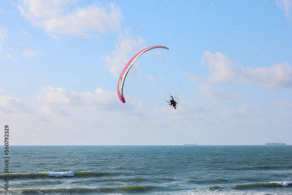 Parachutist flying over sea on summer day Parachutist flying over sea on summer day