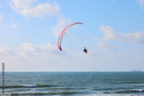 Parachutist flying over sea on summer day