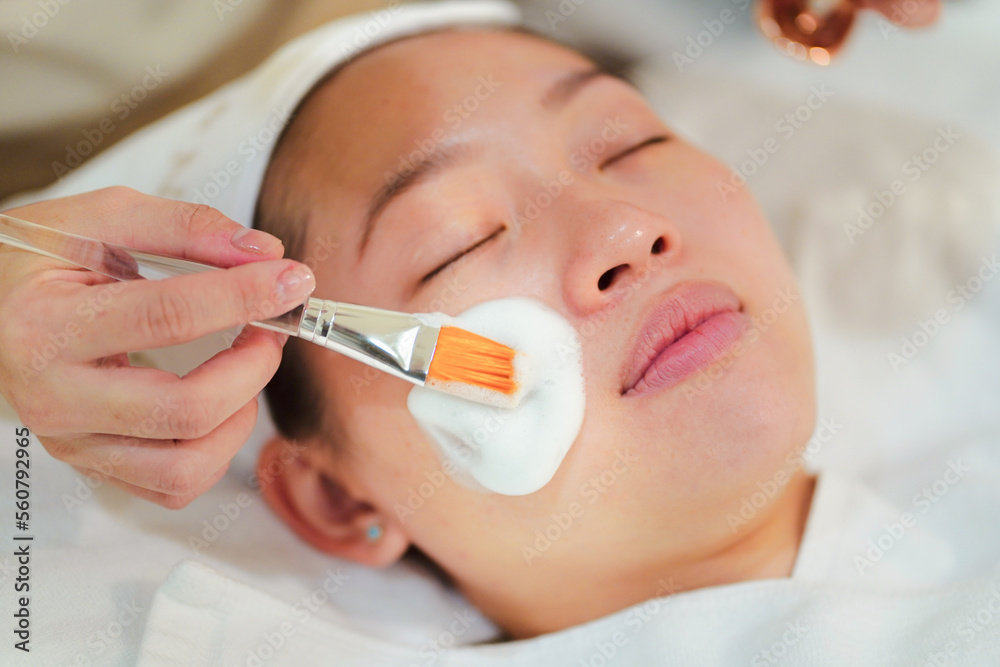 Beautician applying mask on client face