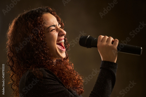 Professional female singer with microphone photo