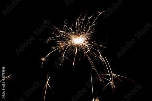 Burning sparkler isolated on black background. Fireworks theme. Light effect and texture.