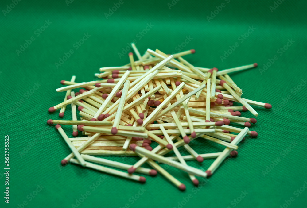A pile of matches on a green background