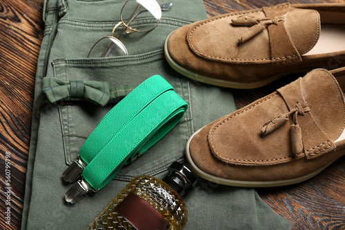 Male clothes, shoes and accessories on wooden background, closeup
