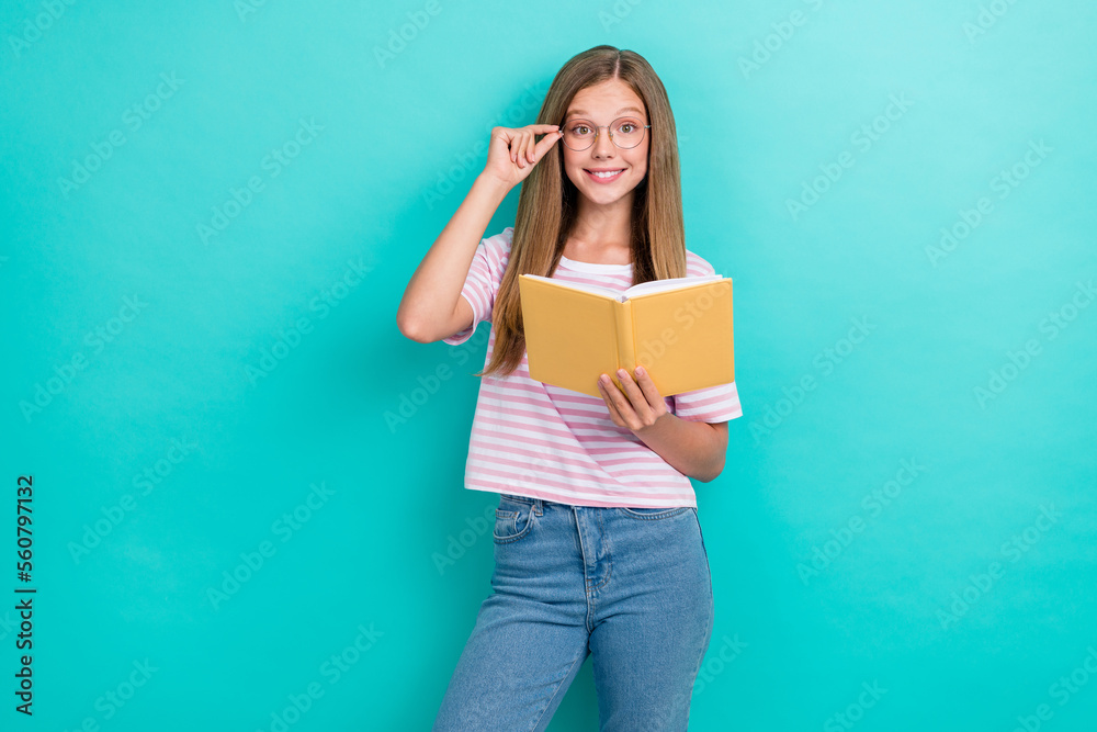 Portrait of cheerful smart person hand touch eyewear hold opened book isolated on cyan color background Portrait of cheerful smart person hand touch eyewear hold opened book isolated on cyan color background