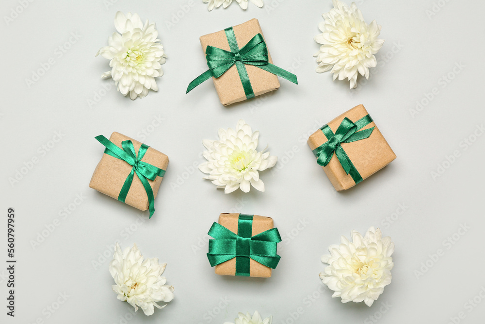 Composition with gift boxes and beautiful chrysanthemum flowers on white background