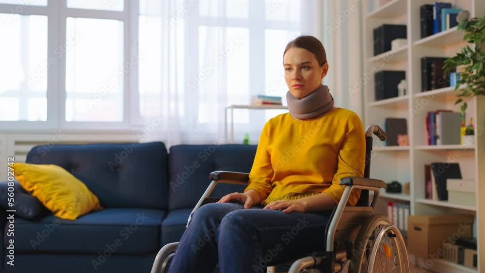 Unhappy young woman in wheelchair with neck collar, injury after accident Unhappy young woman in wheelchair with neck collar, injury after accident