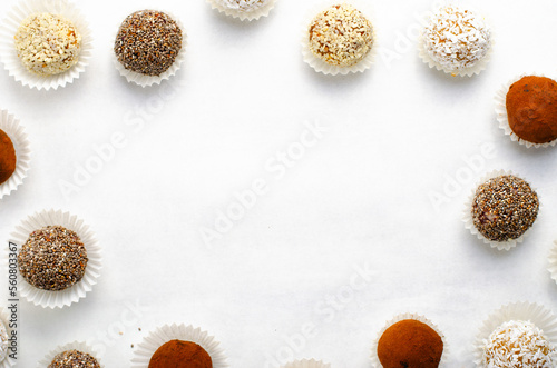 Assorted Vegan Sweets, Delicious Candy Balls with seeds, nuts and cocoa powder, Healthy Candies on Bright Background