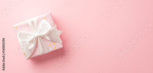Valentine's Day concept. Top view photo of giftbox with white ribbon bow on isolated pastel pink background with copyspace © ActionGP