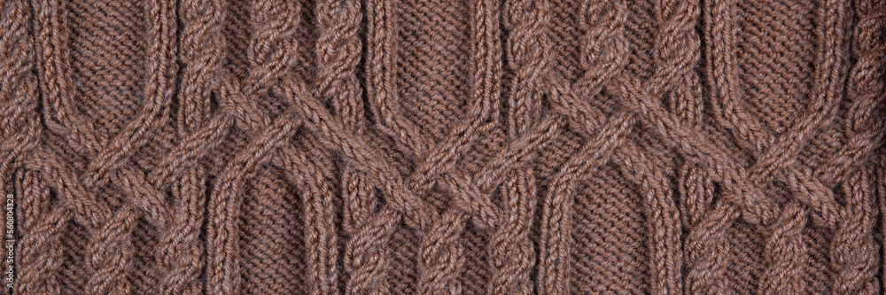 Knitted brown background banner. Large knitted fabric with a pattern. Close-up of a knitted blanket Knitted brown background banner. Large knitted fabric with a pattern. Close-up of a knitted blanket