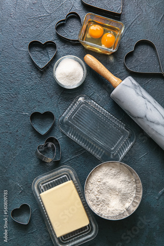 Composition with ingredients and utensils for preparing tasty cookies on dark color background. Valentines Day celebration