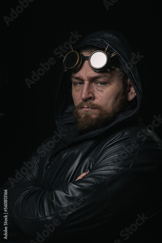 A man in a hood, wearing vintage steampunk goggles looking at the camera close-up © Mk16.15