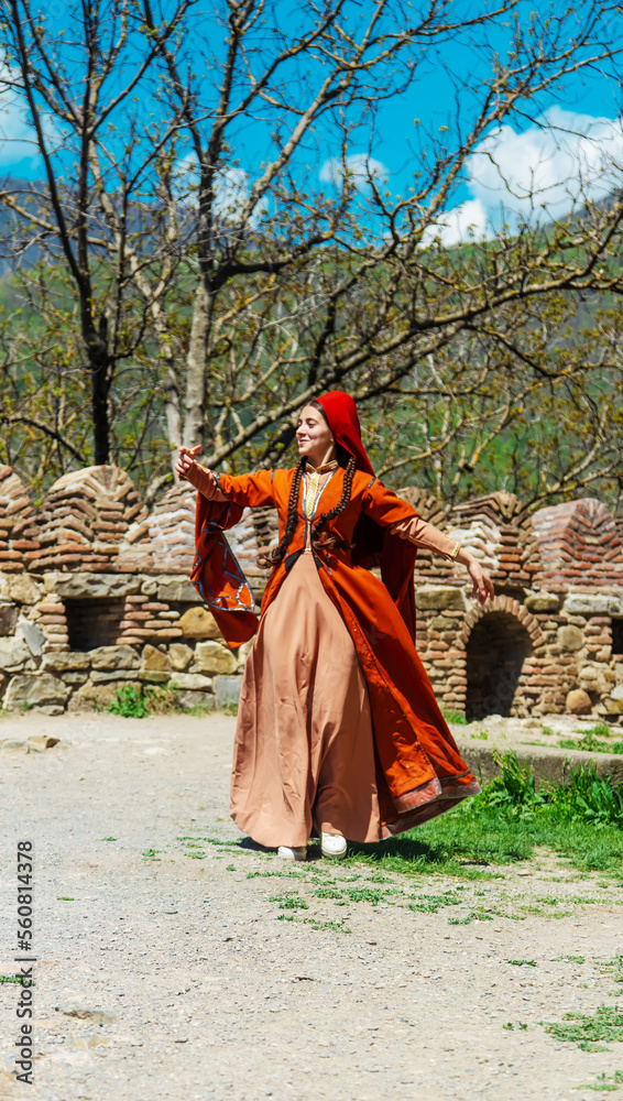 Georgian girl in national costume dances Georgian national dances. selective focus. Georgian girl in national costume dances Georgian national dances. selective focus.