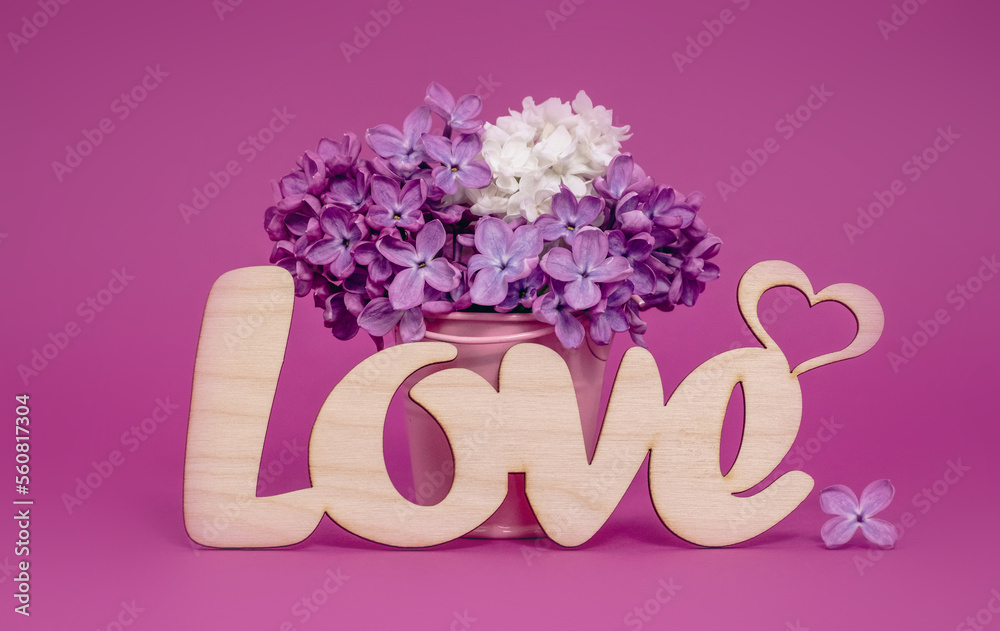 Word Love and lilac flowers on pink background. St. Valentine Day, love or wedding day concept. Romantic pink background with word Love and flowers, copy space Word Love and lilac flowers on pink background. St. Valentine Day, love or wedding day concept. Romantic pink background with word Love and flowers, copy space