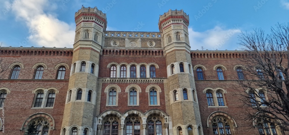 castle-like building with two towers and many windows with red brick