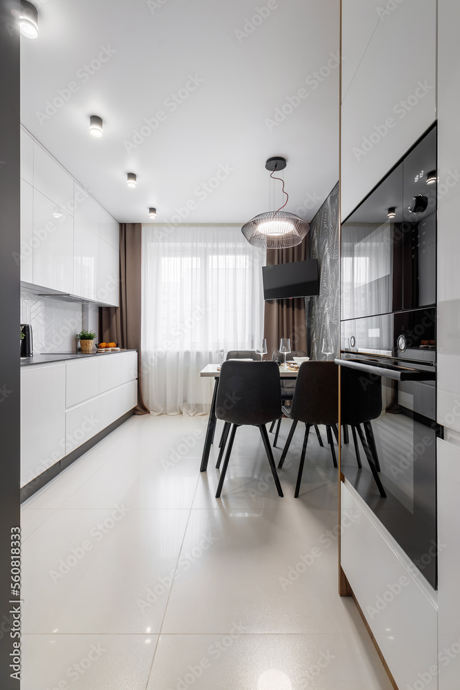 Fototapeta premium Modern cuisine in black in the dining table and kitchen appliances