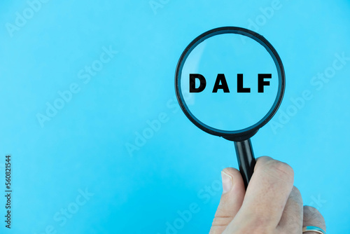 Focused on DALF exam. Word DALF (Diplôme approfondi de langue française) under magnifying glass. French Language Proficiency Test. Test Preparation. E-learning.