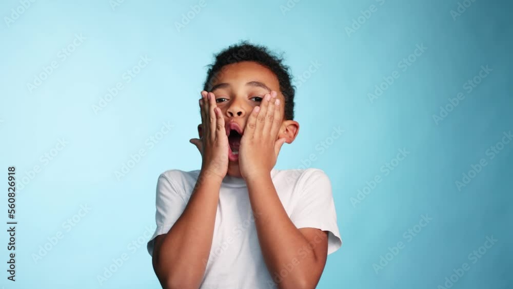 Shocked surprised african american kid opening mouth looking at the camera on isolated blue background Portrait of little boy showing shock or wow emotion by unexpected good news at studio Shocked surprised african american kid opening mouth looking at the camera on isolated blue background Portrait of little boy showing shock or wow emotion by unexpected good news at studio