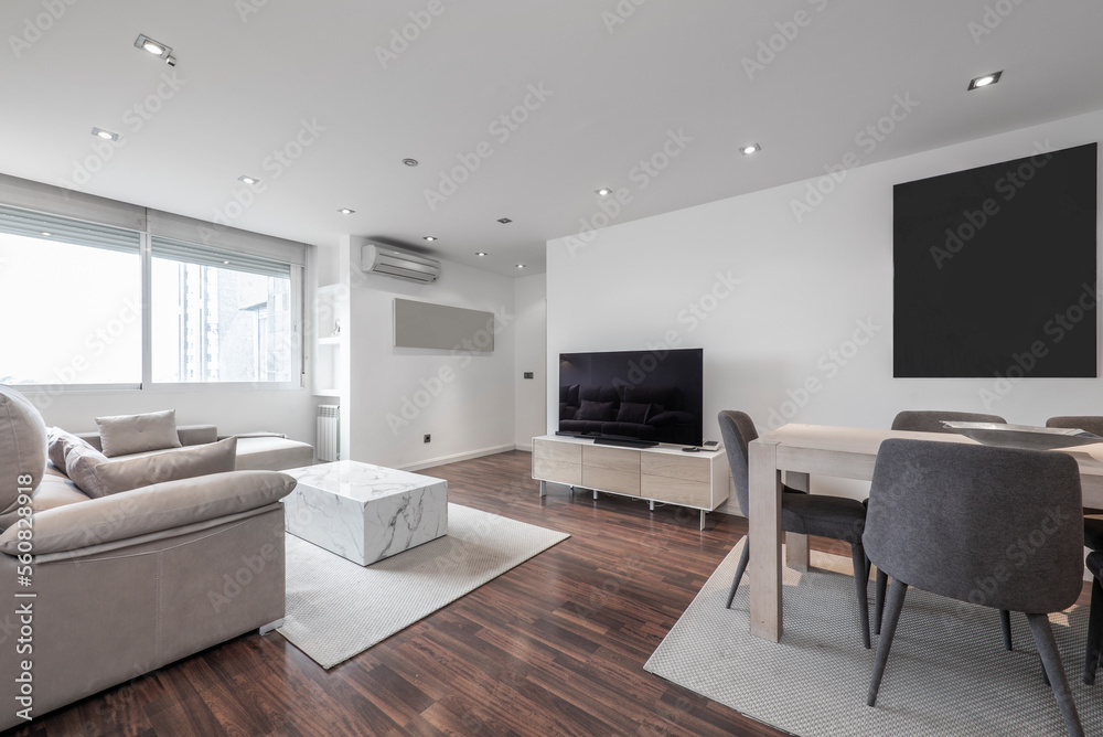 Fototapeta premium Living room of a short-term rental home with modern design furniture in light wood and marble on a dark parquet floor