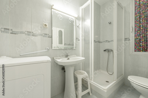 White-toned bathroom with walk-in shower  mirror  and top-loading washing machine