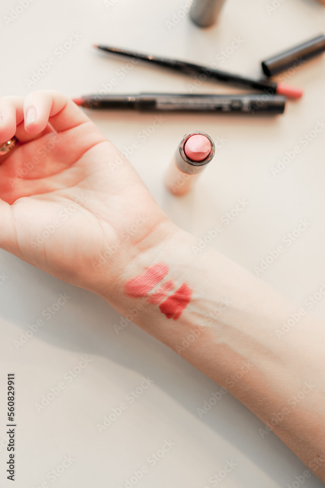 A make-up master choosing a color of a lipstick