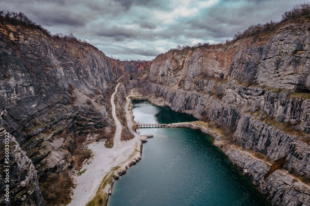 Naklejka premium Aerial view of Velka Amerika,Big America,limestone quarry.Grand Canyon of Czech Republic.Labyrinth of caves,lake with crystal clear water.Popular tourist place,picturesque Czech nature,steep cliffs