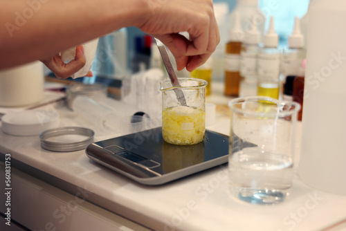 Billede på lærred Put a beeswax in the beaker, weigh jojoba oil on the electronic scale in the lab