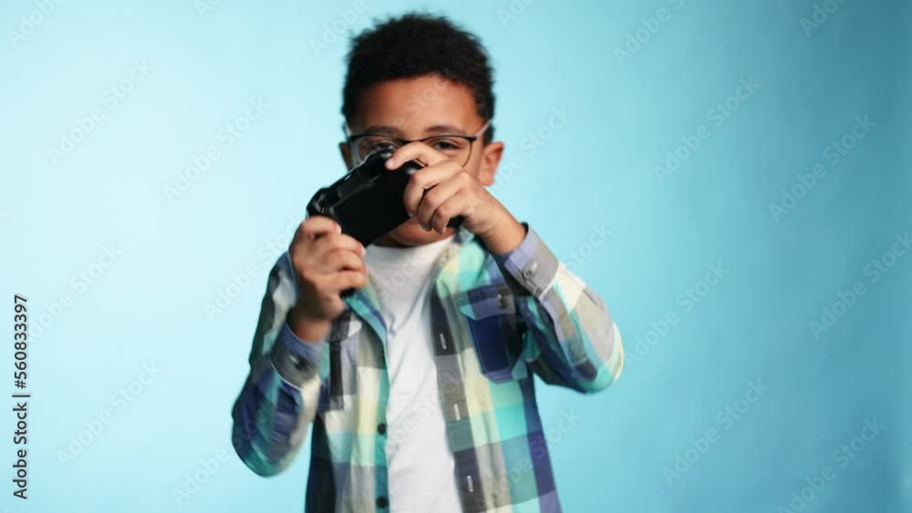 Excited cute little boy kid with joystick controller playing video games on blue background alone Happy child have fun relax after school lessons isolated Game addiction concept Excited cute little boy kid with joystick controller playing video games on blue background alone Happy child have fun relax after school lessons isolated Game addiction concept