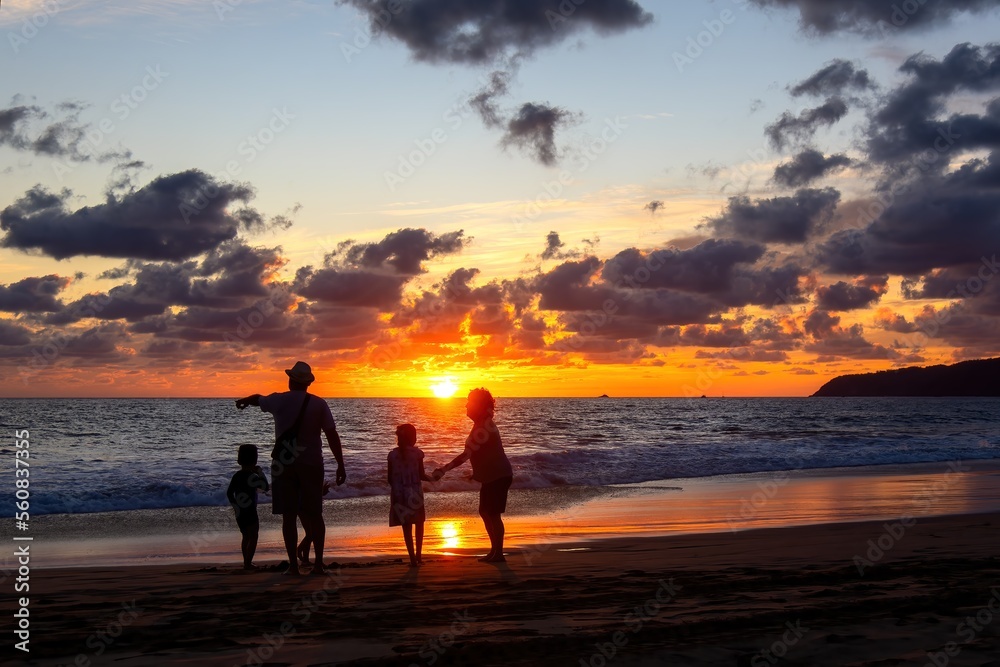 Family playing on the beach at beautiful sunset with sunset