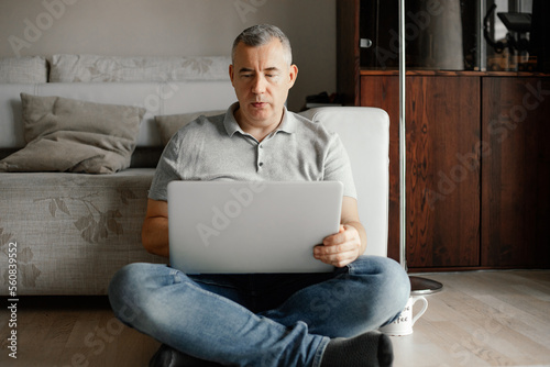 Smart, concentrated serious grizzled man working on laptop indoors. Remote work, occupation. Leadership, counselling © Татьяна Волкова