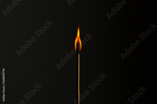 Flame in incense stick burning in the dark