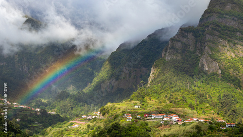 Tropical landscape with rainbow and clouds