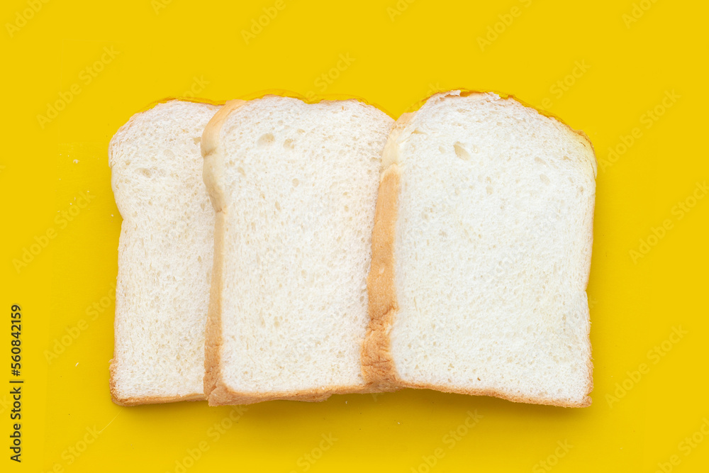 Stack of sliced bread on yellow background.