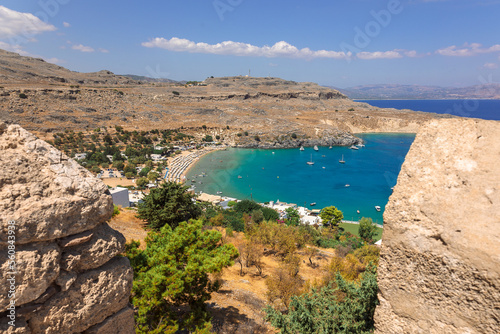 Panoramic view of colorful harbor in Lindos village, Rhodes. Aerial view of beautiful landscape, sea with sailboats and coastline of island of Rhodes in Aegean Sea. High quality photo