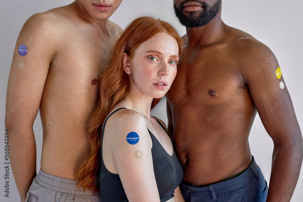 Awesome Redhead Lady In Black Top With Cropped Shirtless Men Friends Posing, After Vaccination Immunization. Portrait On White Studio Background. Confident Youth After Injection. Coronavirus, Omicron