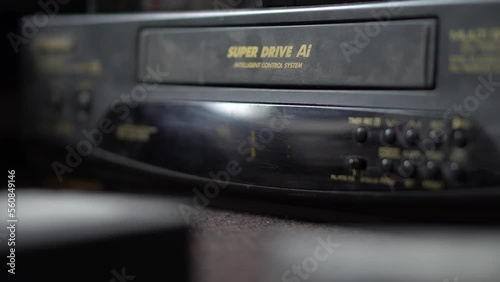 A man inserts a video cassette into a VCR