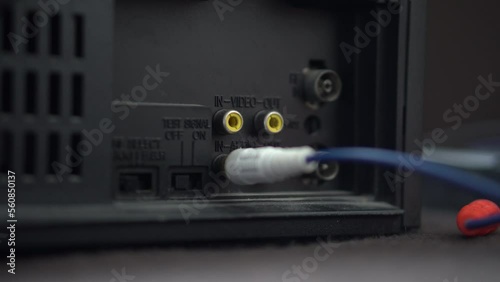 A man connects a cable to the VCR,DVD