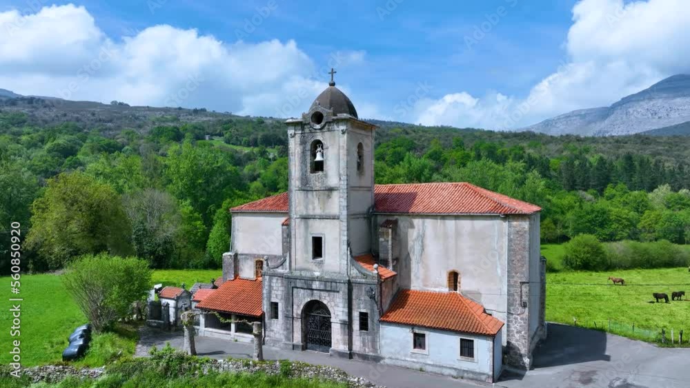 Aerial view from a drone of the Church of San Pedro Apostol in the surroundings of the town of Riva. Ruesga Valley. Hills of the Ason Natural Park. Cantabria, Spain, Europe Aerial view from a drone of the Church of San Pedro Apostol in the surroundings of the town of Riva. Ruesga Valley. Hills of the Ason Natural Park. Cantabria, Spain, Europe