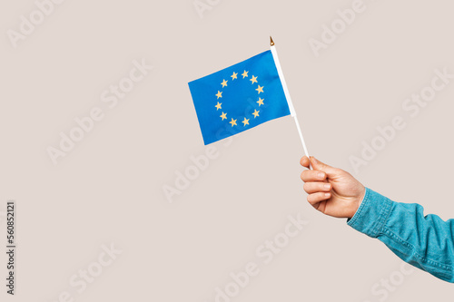 Close up shot of a male hand holding the European Union blue flag with stars. © Vulp